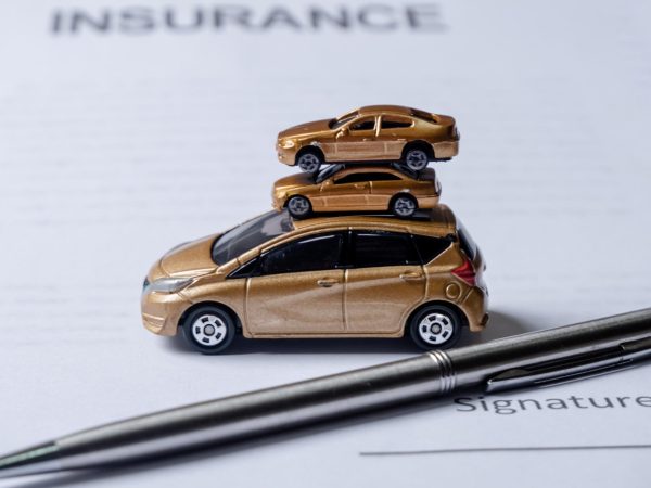 Car and pen on insurance documents. Car insurance concept.
